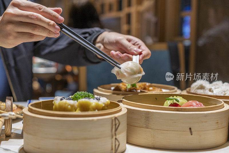 人们用筷子和勺子吃广东dum sum虾饺